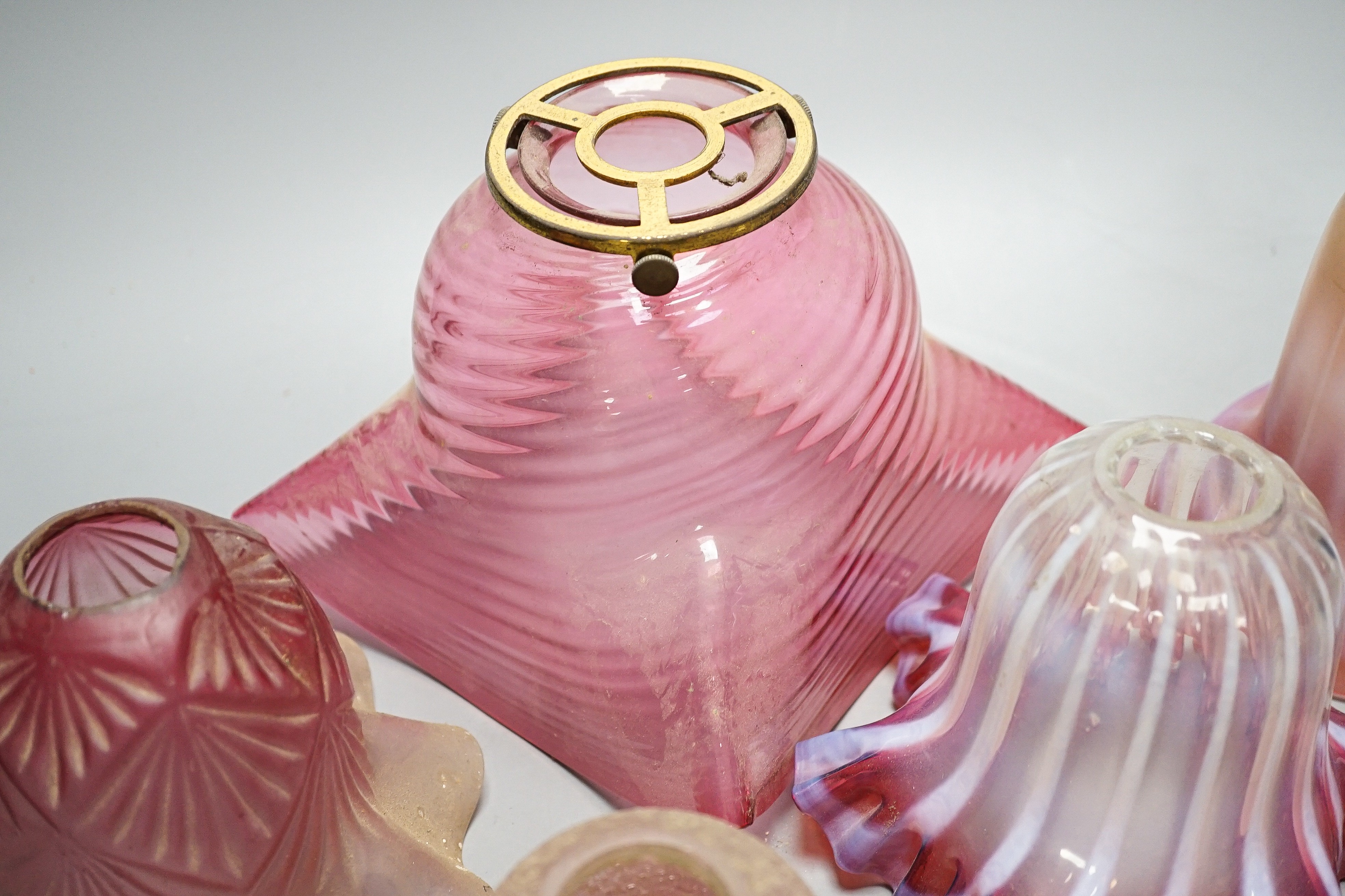 Six various cranberry glass lamp shades, two with opalescence, largest 16 cms high.
